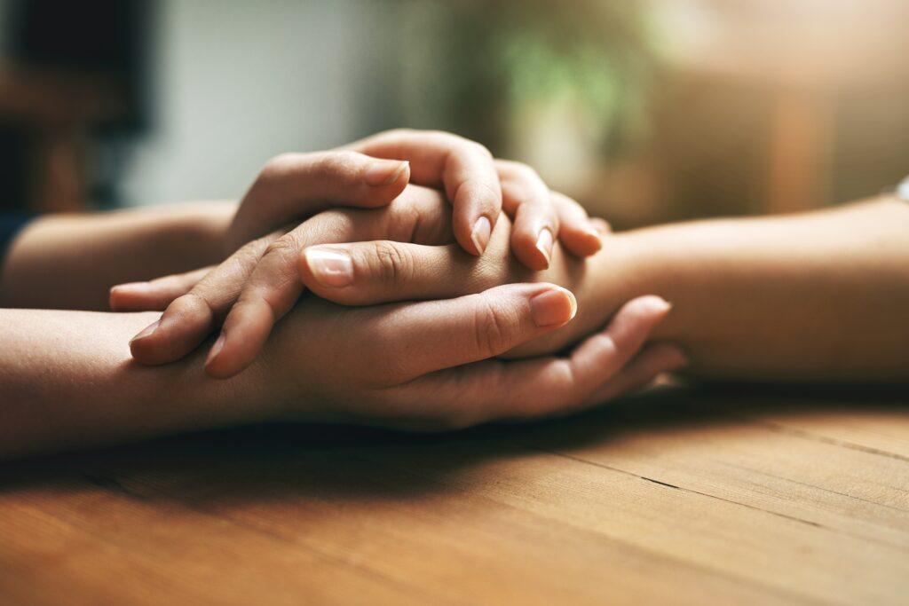 two-people-holding-hands-in-support